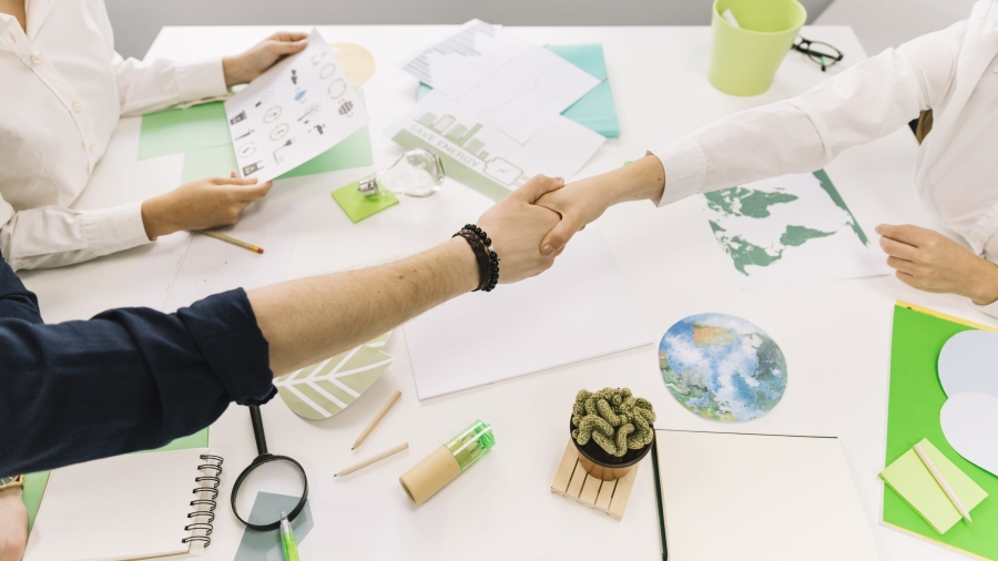 empresario-estrecharme-la-mano-con-su-companero-sobre-el-escritorio